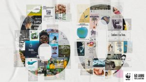 Collage celebrativo composto da decine di manifesti, campagne e immagini storiche del WWF, disposti a formare la cifra "60" su sfondo chiaro. Tra i contenuti riconoscibili: un lupo con la scritta "Salva il lupo, firma ora!", una mela dipinta di blu con la scritta "Sono avvelenata", un orso bruno in bianco e nero, un manifesto con un pesce spada e la scritta "Orribile", una manta, uno scimpanzé, una tartaruga, immagini di attivisti in tuta gialla, e vari altri poster con slogan ambientali in italiano. In basso a destra, il logo del panda WWF con la scritta "60 anni per la natura". Immagine composita a colori.